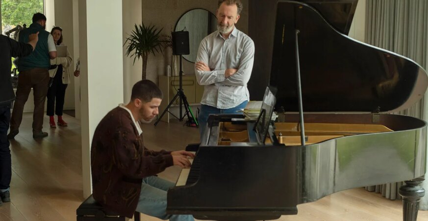 Nick Jonas as Danny and Director John Carney in Power Ballad.