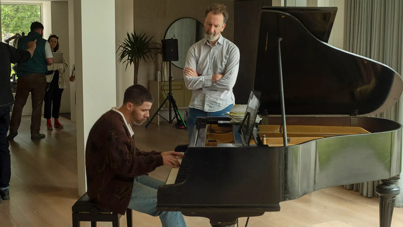 Nick Jonas as Danny and Director John Carney in Power Ballad.